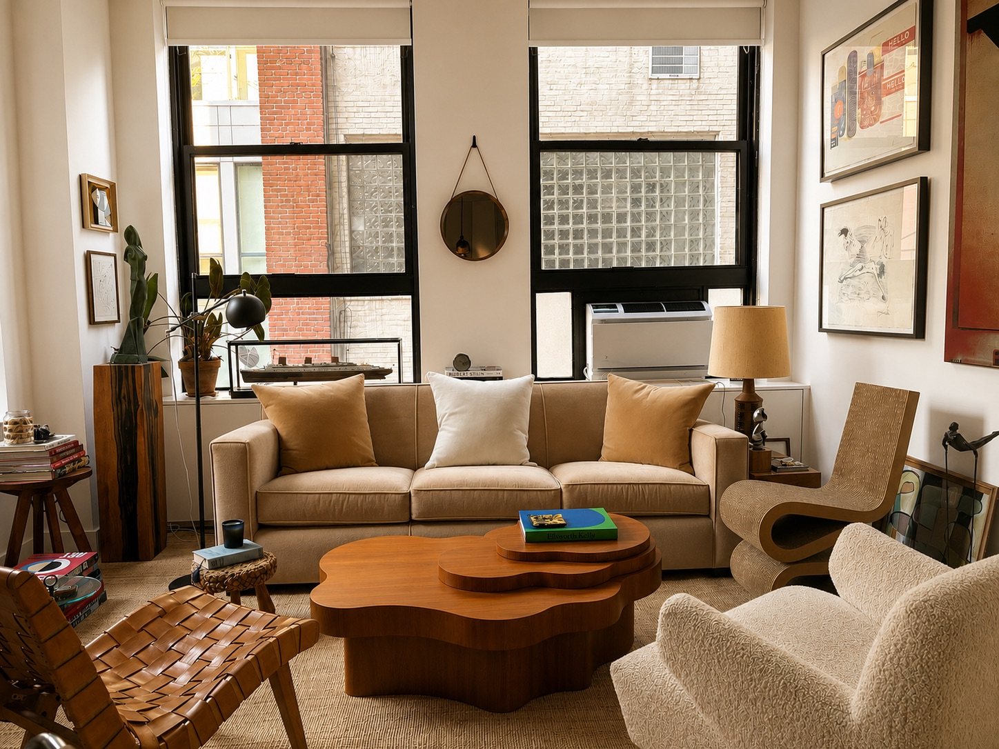 Living room with a cream sofa, biomorphic walnut coffee table and framed works on the wall
